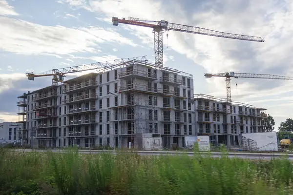 Poznan, Polonya - 13 Temmuz 2025: Konut binasının inşaat halindeki beton iskeleti, Gran ve POTAIN vinçleri modern kentsel genişlemeyi simgeliyor