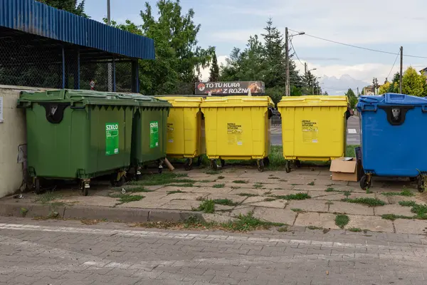 Swarzedz, Polonya - 13 Temmuz 2025: Cam, metal, plastik, kentsel atık ayrımının kolaylaştırılması ve sürdürülebilir yönetim için açık yeşil, sarı, mavi geri dönüşüm kutuları