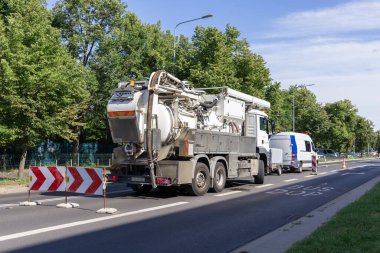 Poznan, Polonya - 16 Temmuz 2025: Beyaz Kroll endüstriyel kanalizasyon temizleme kamyonu özel ekipmanlarla birlikte bir şehir yoluna park edilmiş, önemli altyapı bakımını destekliyor
