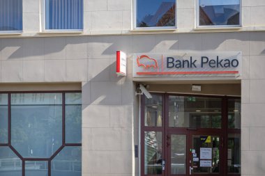 Poznan, Polonya - 16 Temmuz 2025: Pekao Bankası ikonik kırmızı bufalo logosu, finansal hizmetlerdeki rolünü vurgulayarak çağdaş bir bina cephesinde sergilendi