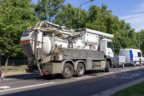 Poznan, Polonya - 16 Temmuz 2025: Bir şehir caddesinde özel KROLL geri dönüşüm kamyonu ve AQUANET servis minibüsü, hayati kamu sağlık hizmetleri ve kentsel altyapı bakımını betimliyor
