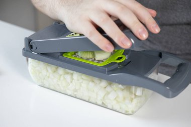 Bir elin yukarıdan aşağı bakış açısı pratik bir mutfak diktatörü, temiz beyaz soğan işleme, uygun ev yemeği ve mutfak verimliliği için ideal