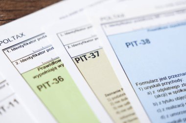 Poznan, Polonya - 20 Temmuz 2025: Polonya 'nın çeşitli gelir vergisi formlarının düzenlenmesi, PIT-36, PIT-37, PIT-38, ulusal mali yükümlülükleri ve ekonomik bürokrasiyi temsil ediyor