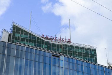 Poznan, Polonya - 10 Ağustos 2025: Andersia binasının modern cam cephesi ve çarpıcı kırmızı çatı tabelaları mavi gökyüzüne karşı, kentsel tasarım sergileniyor