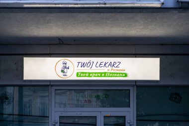 Poznan, Polonya - 10 Ağustos 2025: Aydınlatılmış bir tabela üzerindeki Twoj Lekarz damgası, genel sağlık hizmetleri için bir klinik girişini vurguluyor