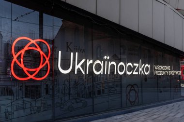 Poznan, Polonya - 10 Ağustos 2025: Kültürel gıda pazarını sembolize eden, parlak ışıklı marka tabelasını ve belirgin kırmızı dairesel logosunu vurgulayan Ukrayna mağazasının yakın çekim görüntüsü