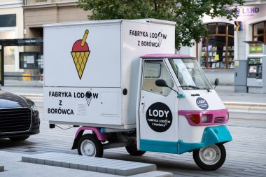 Poznan, Polonya - 10 Ağustos 2025: Canlı pembe ve deniz mavisi aksanlı küçük mobil tatlı minibüsü şehir kaldırımına park edilmiş, havalı ikramlar sunuyor