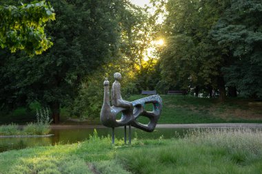 Poznan, Polonya - 10 Ağustos 2025: Huzurlu bir doğal ortamda özenle hazırlanmış kuş benzeri bir yaratığın üzerinde eşsiz bir insan figürü sergilenen sanatsal halk sanatı kurulumu