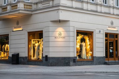 Poznan, Polonya - 10 Ağustos 2025: Buczynski mağazası, vitrinleri şık kıyafetler ve şehir perakendecisi için şenlikli dekorlar sergileyen parlak bir köşe binası