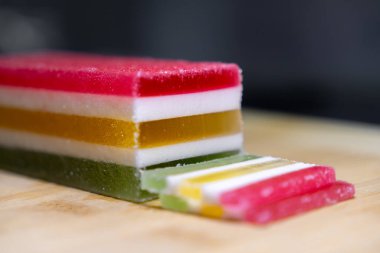 Canlı katmanlı, şeker kaplı, ahşap bir yüzeyde şeker kaplı bir şeker kalıbının yakın görüntüsü, lezzetli bir tatlı ya da şenlikli bir şekerleme ikram ediyor.