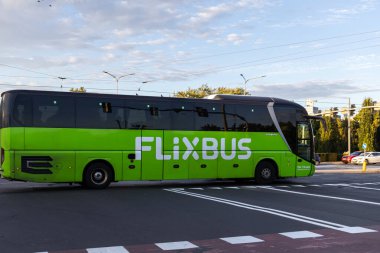 Poznan, Polonya - 5 Eylül 2025: İşaretli bir sokakta seyahat eden yeşil Flixbus otobüsünün yan görüntüsü, kentsel bölgeler için sürdürülebilir uzun mesafe yolcu taşımacılığını sembolize ediyor