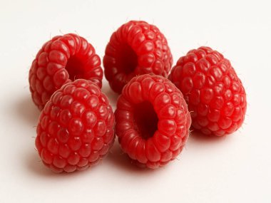 Beyaz bir yüzeyde bir grup ahududu.