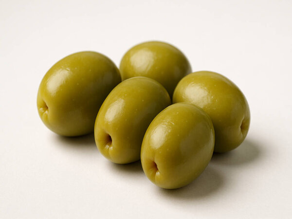 a group of olives on a white surface