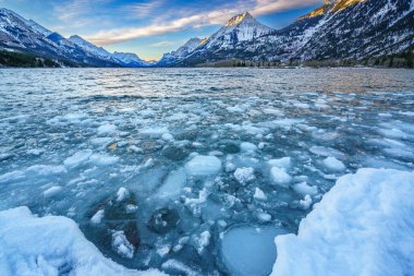 Ice floating on the surface of Waterton Lake as it starts to freeze with the onset of winter clipart