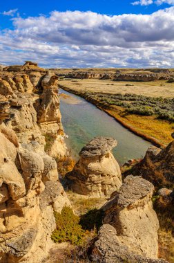 Weathered sandstone rock formations along the Milk River in Writing-On-Stone Provinvial Park, Alberta clipart