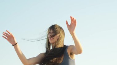 A mesmerizing dance unfolds on the pier in Alameda as a woman moves gracefully beneath the fiery sunset sky.