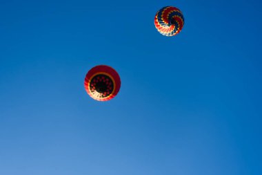 Mavi gökyüzünde uçan sıcak hava balonu