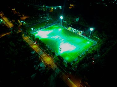 Sports team playing football at the stadium, at night clipart