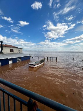 Güneşli gökyüzüyle dolu nehir taşkınından dolayı sel basmış avluyu 