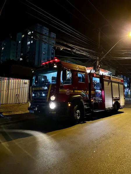 stock image Military fire truck on the street with dark sky and visible internal lighting 