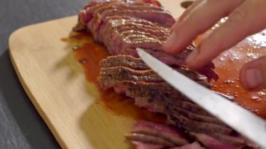 Aşçı ahşap tahtada bıçakla kesilmiş sığır eti kızartma ortasında
