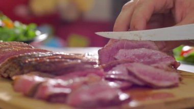 Aşçı ahşap tahtada bıçakla kesilmiş sığır eti kızartma ortasında