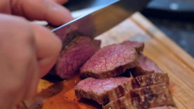 Aşçı ahşap tahtada bıçakla kesilmiş sığır eti kızartma ortasında