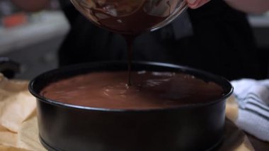 Çikolata jölesi bir pasta kalıbının üzerine dökülür. Yakın plan. Yüksek kalite 4k görüntü