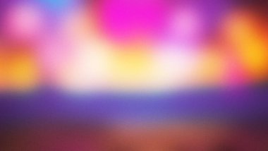 Pembe, sarı, turuncu ve mor renkli canlı bir gradyan içeren yumuşak, bulanık ve soyut bir arkaplan..