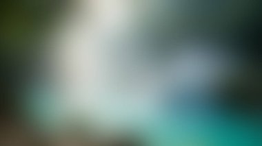 Yumuşak bulanık bir görüntü bir şelalenin özünü yakalar, akan su ve çevreleyen yemyeşil yeşil soyut, sakin bir manzara yaratır..