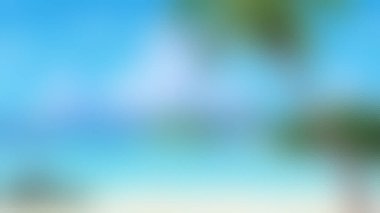 Berrak mavi gökyüzü, turkuaz su ve palmiye ağaçlarının izlerine sahip sakin bir tropikal plajın yumuşak odak noktası..