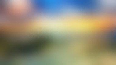 Soğuk maviler ve yeşilliklere karşı ılık sarılar ve portakalların karışımından oluşan bulanık bir görüntü, nazik ve atmosferik bir etki yaratıyor..