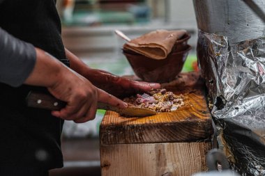 Man preparing authentic carnitas at a Mexican street food market, showcasing the traditional cooking process with rich textures and vibrant colors. Perfect for culinary, cultural, and street food themes clipart