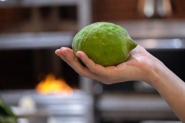 Restoranda şefin elinde büyük yeşil limon