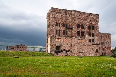 Historical Abandoned Industrial Buildings with International Bridge Crossing in Background  Green Grass Foreground clipart