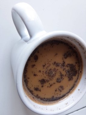 Beyaz arka planda bir fincan sıcak süt kahve.