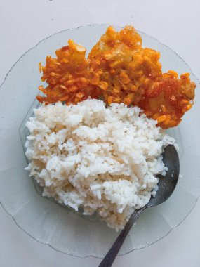 Bir tabak pilav ve yanında mısır çorbası hazır.