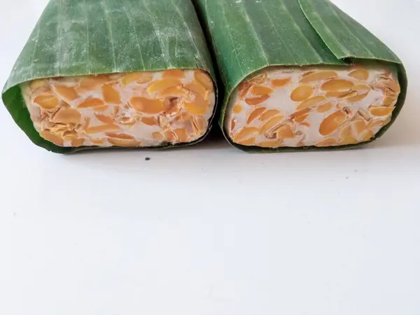 stock image tempeh wrapped in banana leaves isolate on white