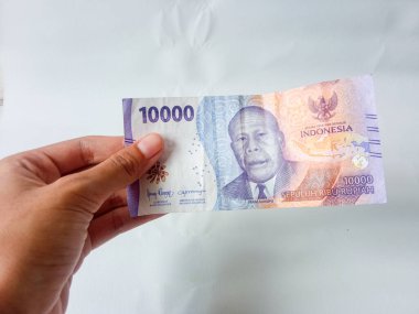 El ele tutuşan on bin rupiah banknot, izole edilmiş beyaz arka plan.