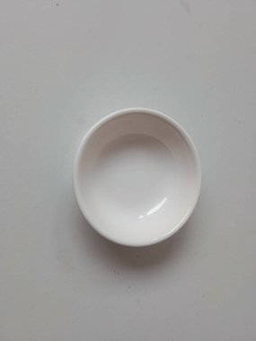 El ele tutuşan çay tabağı beyazda izole edilmiş.