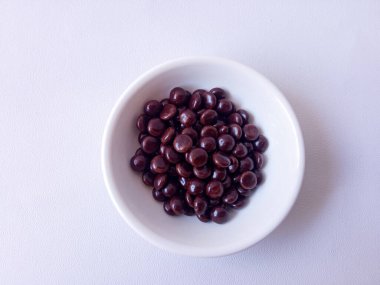 Çikolata kaplı fıstık şekeri ya da beyaz arka planda izole edilmiş çikolata topları.