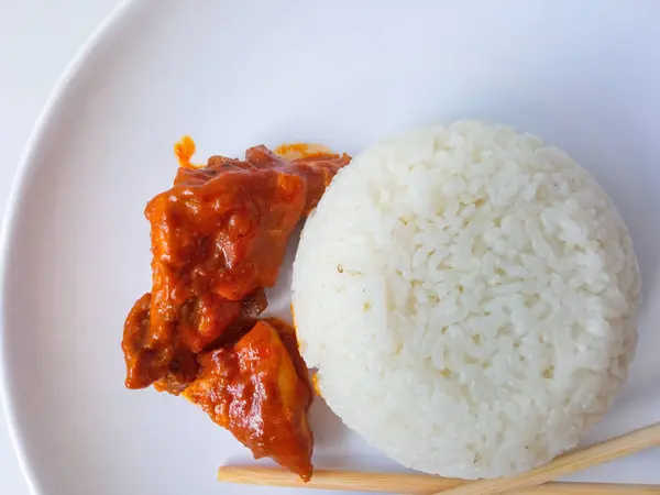 stock image rice with padang rendang chicken side dish on a white plate isolate on white