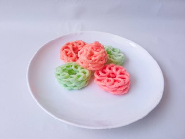 Beyaz tabaktaki renkli krakerler izole edilmiş.