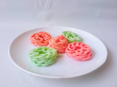 Beyaz tabaktaki renkli krakerler izole edilmiş.