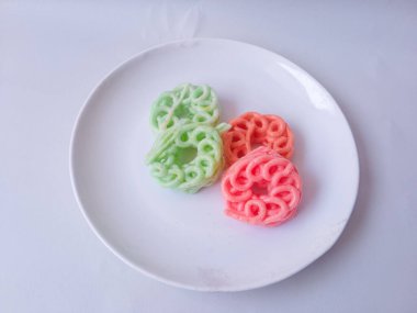 Beyaz tabaktaki renkli krakerler izole edilmiş.