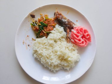 Bir tabak pilav, yanında pekel tabağı ve kızarmış ton balığı ve sambal balığını beyaza ayır.