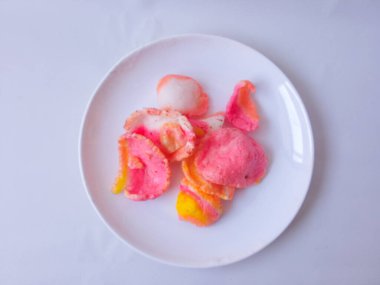 Beyaz bir tabakta çıtır çıtır pembe krakerler ve beyaz bir tabakta izole edilmiş..