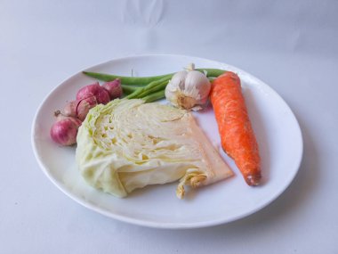 lahana, havuç, yeşil fasulye, tabakta kırmızı soğan sarımsağı ve beyazı izole et. Sağlıklı gıda konsepti. diyet menüsü kavramı