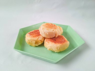 bakpia jogja. Jogja 'nın tipik hatıraları. Yeşil bir altıgen tabakta yeşil fasulye aromalı bakpia ve beyaz üzerine izole edilmiş. Hatıra yemeği konsepti.
