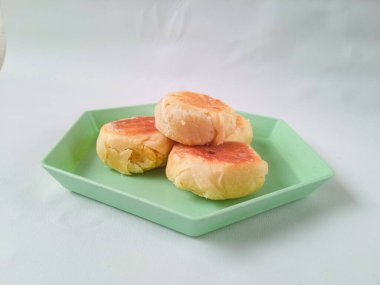 bakpia jogja. Jogja 'nın tipik hatıraları. Yeşil bir altıgen tabakta yeşil fasulye aromalı bakpia ve beyaz üzerine izole edilmiş. Hatıra yemeği konsepti.